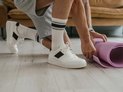 Close-up of comfortable sportswear and a yoga mat on a wooden floor.