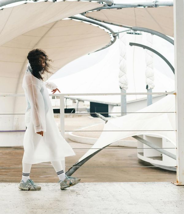 Person engaged in a fluid, gentle movement in a minimalist space.